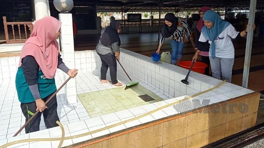 KAKITANGAN CTRM Melaka bergotong-royong membersihkan kolah masjid An Nur Peringgit. FOTO Nazri Abu Bakar