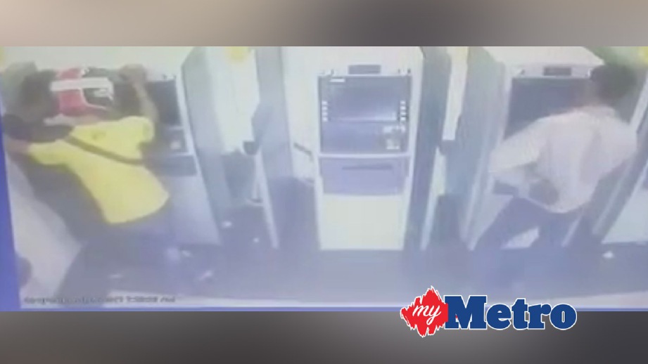 RAKAMAN CCTV menunjukkan suspek (kiri) mengumpil pintu mesin ATM walaupun pelanggan lain (kanan) sedang berurusan.