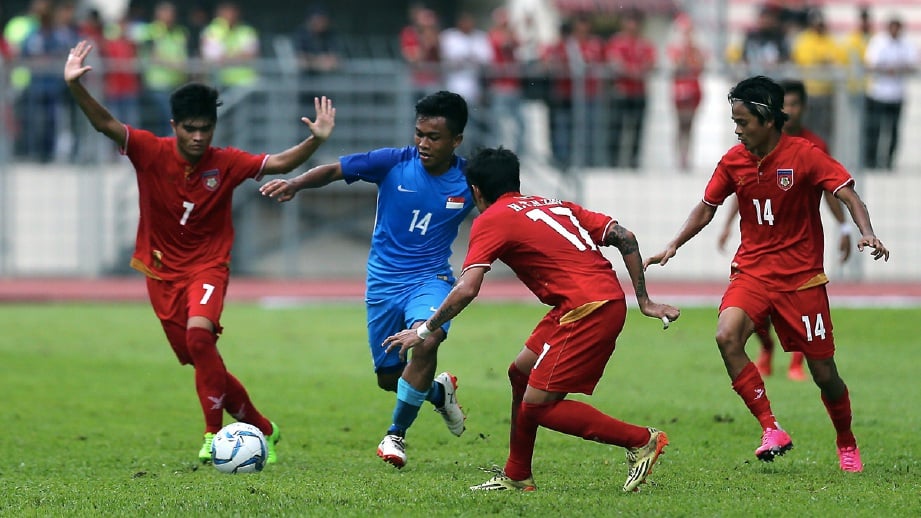 PEMAIN Singapura, Muhammad Hami Syahin Said (dua dari  kiri) dilawal tiga pemain Myanmar. -Foto LUQMAN HAKIM ZUBIR