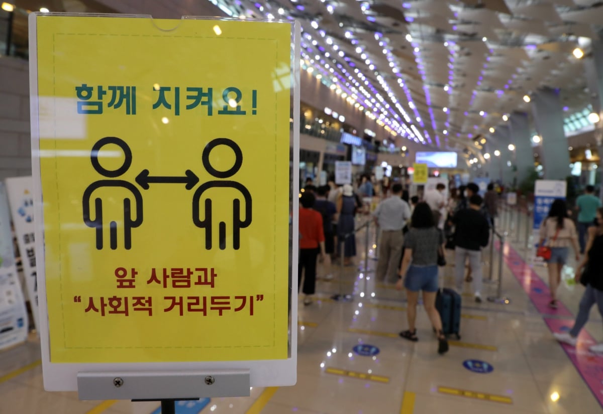 NOTIS arahan penjarakan fizikal sebagai langkah pencegahan Covid-19, di Lapangan Terbang Gimpo, Korea Selatan. FOTO EPA 