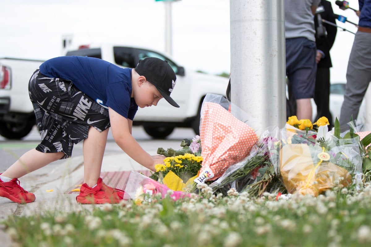 KANAK-KANAK meletakkan patung Hulk di celah kalungan bunga sebagai memperingati mangsa yang terbunuh dan parah dalam kejadian berkenaan. FOTO AFP 