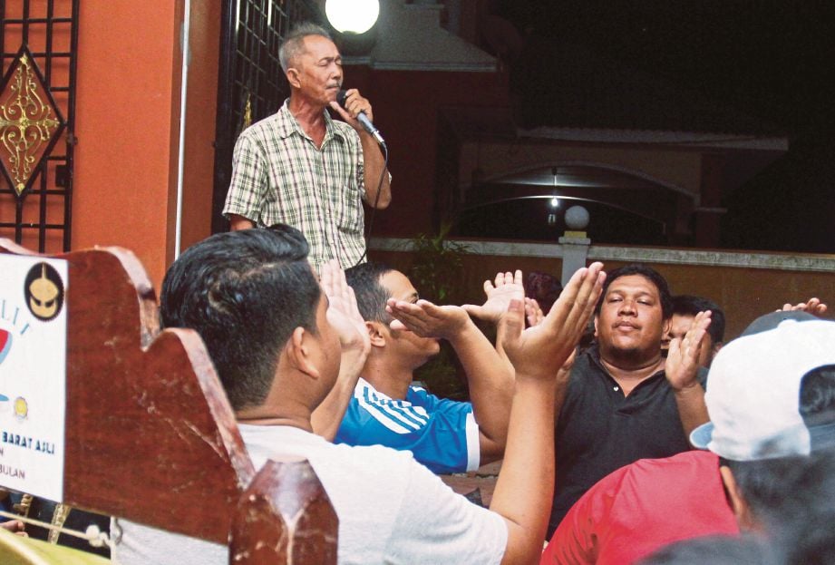 Mohd Ridzuan Tan (kiri) bersama kumpulan dikir barat asli Sri Satelit mendendangkan nyanyian dikir barat Melayu Kelantan di Pasir Tumboh.