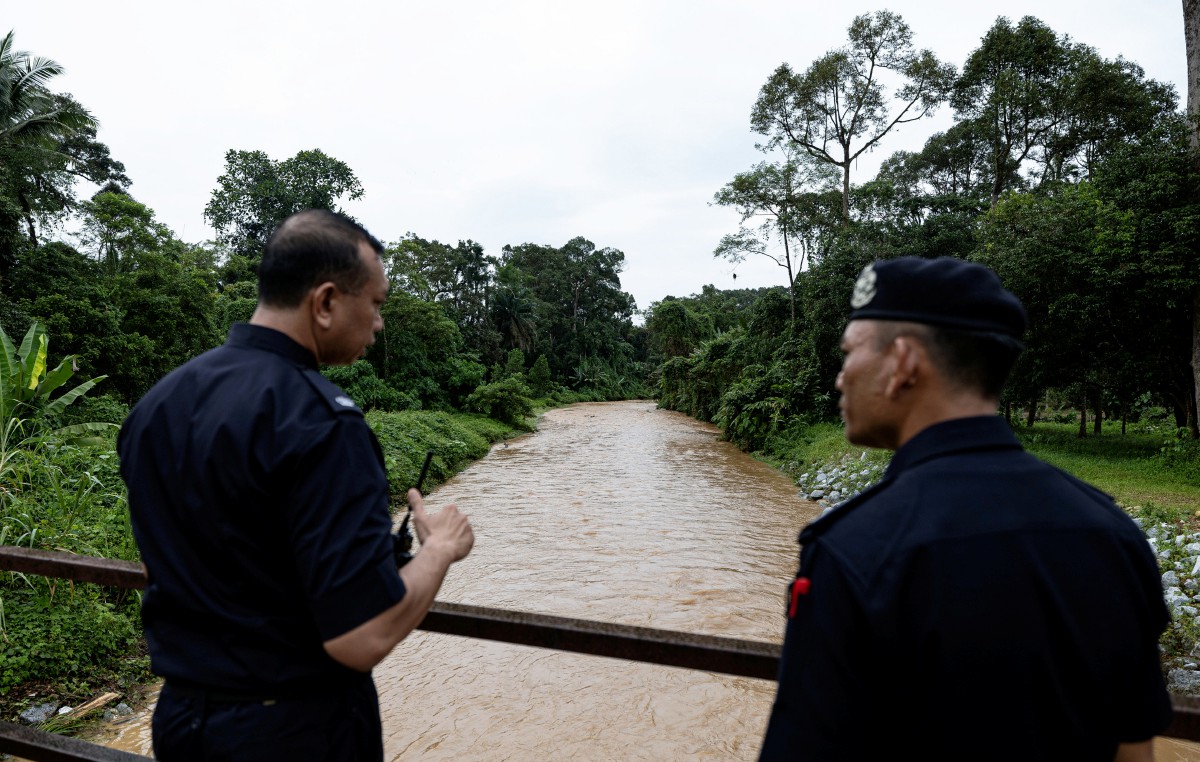 KETUA Polis Daerah Tapah Supt Mohd Naim Asnawi  (kanan) meninjau keadaan sungai selepas tragedi kepala air di Sungai Kenjur, Kampung Poh, Bidor. FOTO Bernama.