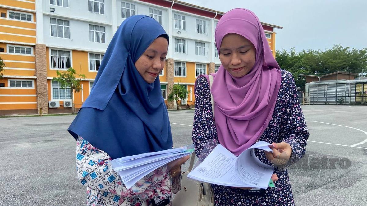NUR 'Alya (kiri) bersama Nur 'Ainaa meneliti borang kemasukan selepas mendaftar masuk ke UMK. FOTO Hazira Ahmad Zaidi