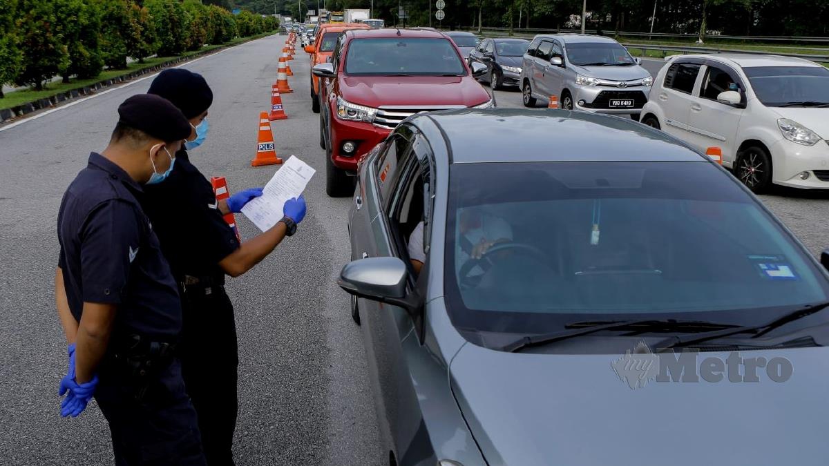 ANGGOTA Polis memeriksa dokumen perjalanan kenderaan yang melalui sekatan jalan raya di Plaza Tol Gombak menuju Pantai Timur. FOTO Asyraf Hamzah