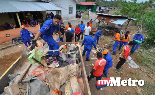 ANGGOTA JPAM negeri dan kakitangan MPAG membantu membersihkan kawasan persekitaran rumah penduduk di Kampung Bukit Balai, Durian Tunggal. FOTO Muhammad Hatim Ab Manan