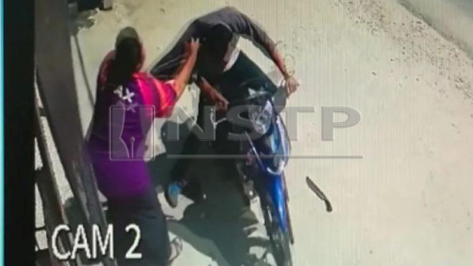 RAKAMAN CCTV menunjukkan mangsa menarik baju suspek menyebabkan dia tidak dapat mengawal motosikal dan melanggar cermin serta tiang kedai sebelum terjatuh. FOTO ihsan Polis