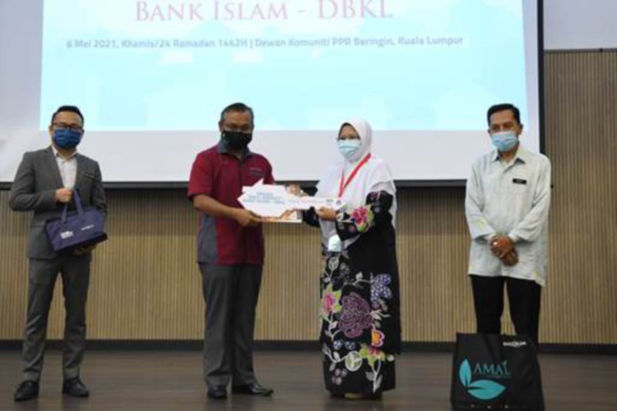 PENGURUS Besar Hubungan Strategik Bank Islam, Mohd Nazri Chik (dua dari kiri) menyampaikan replika kunci kepada salah seorang penerima terpilih di bawah Projek Baiti Jannati di PPR Beringin. 