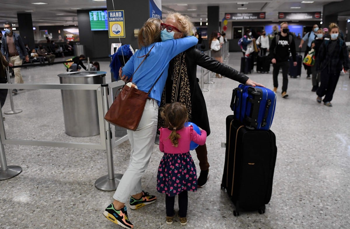 Jeannette Feuth  dari Belanda memeluk anaknya, Femke dan disaksikan cucu, Phila selepas tiba di Lapangan Terbang Antarabang Dulles, Virginia. FOTO AFP.