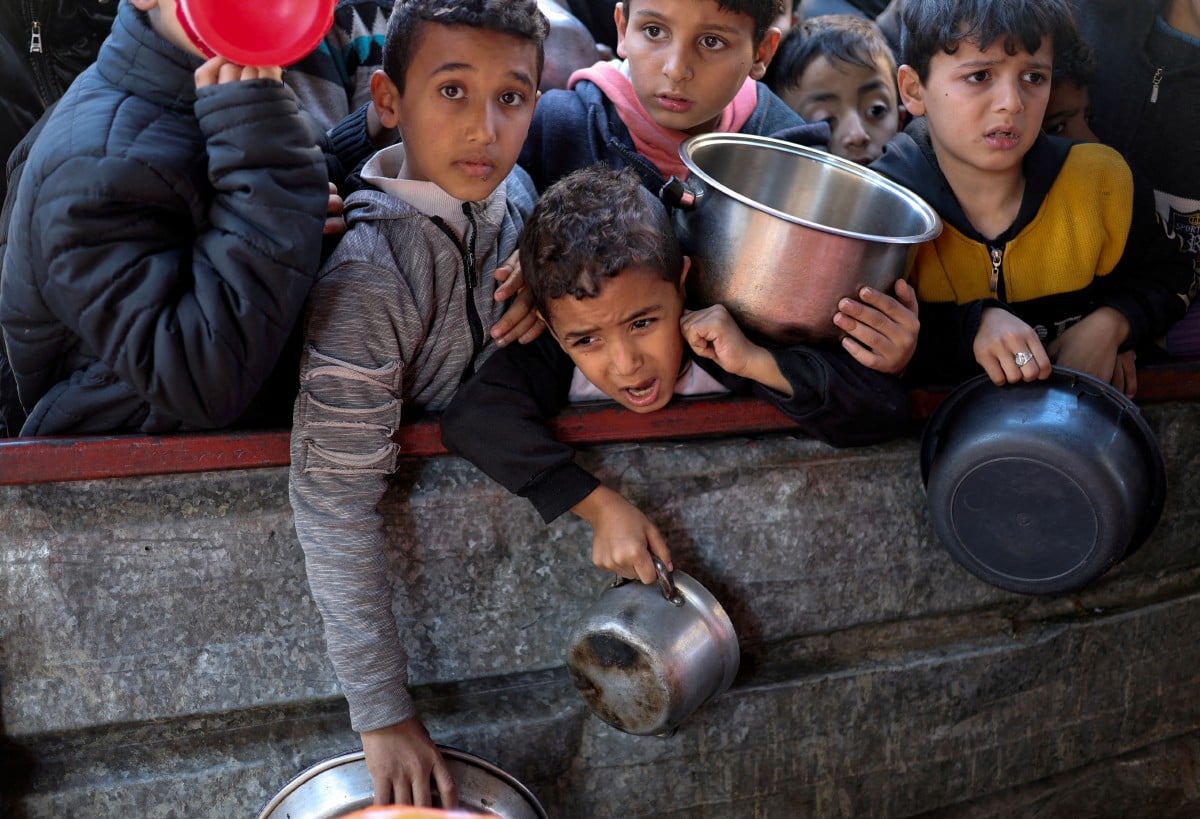 GAMBAR fail kanak-kanak Palestin menunggu makanan dimasak, dalam situasi kekurangan bekalan makanan akibat konflik berterusan. FOTO Reuters.