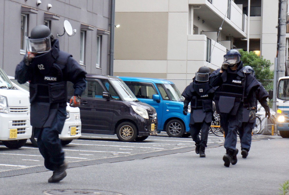 POLIS meninggalkan kediaman suspek di Nara selepas pemeriksaan. FOTO EPA.