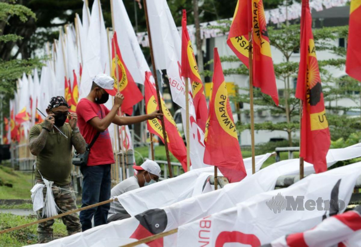 SUKARELAWAN memasang bendera Gabungan Parti Sarawak (GPS) dan Parti Sarawak Bersatu (PSB). FOTO Aizuddin Saad.
