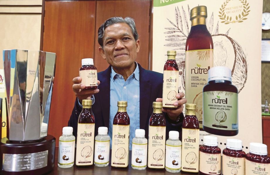 Prof  Mohamad Roji menunjukkan produk minyak kelapa dara yang menerima Anugerah Akademik Negara ke-11.