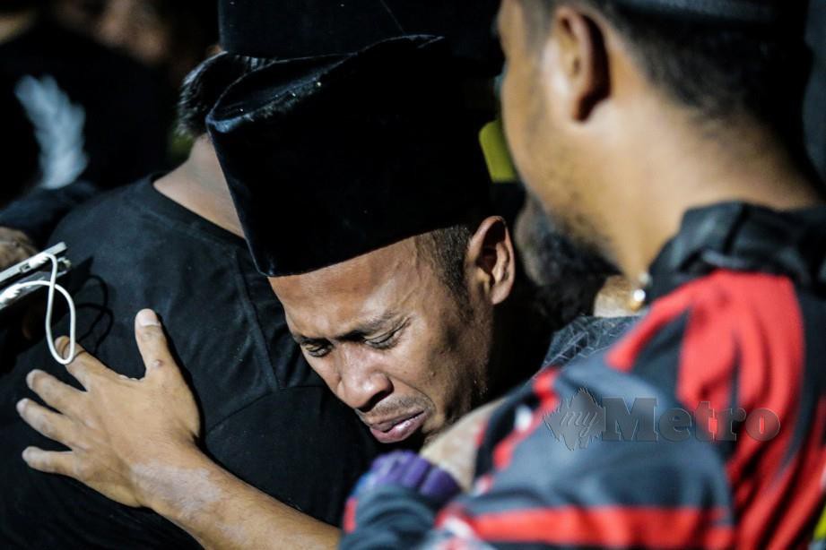 Achey tidak dapat menahan kesedihan selepas Abam selamat dikebumikan di Tanah Perkuburan Islam Jalan Sungai Pusu. FOTO/ASYRAF HAMZAH