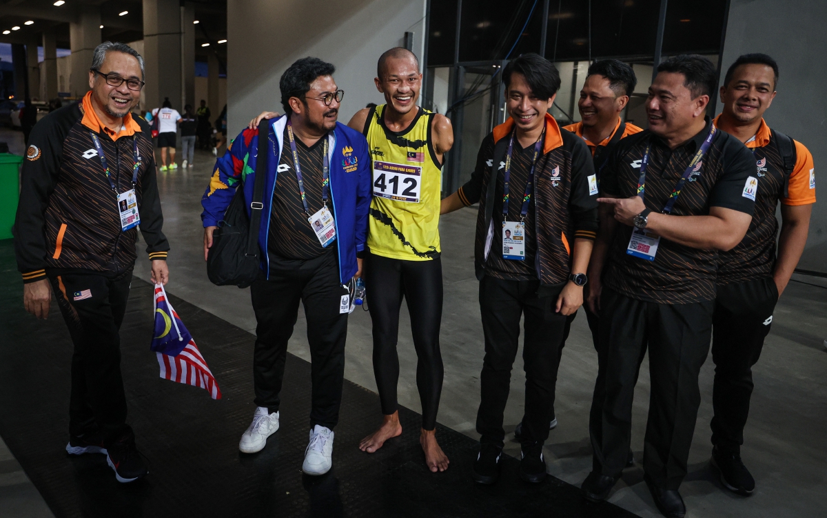 TIMBALAN Menteri Belia dan Sukan Adam Adli Abd Halim (empat, kiri) dan Presiden Majlis Paralimpik Malaysia (MPM) Datuk Seri Megat D Shahriman Zaharudin (dua, kiri) beramah mesra bersama Muhamad Ashraf ketika tiba di Kemboja hari ini.