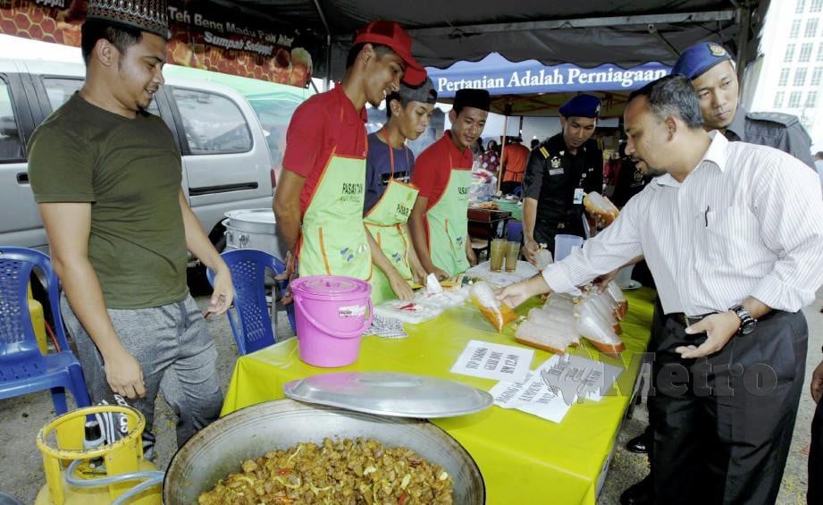 Adnan (kanan) bersama pegawai penguart kuasa melakukan pemantauan bazar Ramadan di pekarangan Stadium Sultan Muhammad IV, Kota Bharu. Foto Syamsi Suhaimi