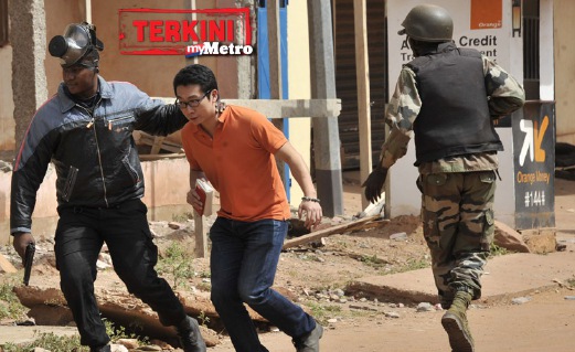 ANGGOTA keselamatan Mali menyelamatkan seorang lelaki berhampiran hotel Radisson Blu. FOTO AFP