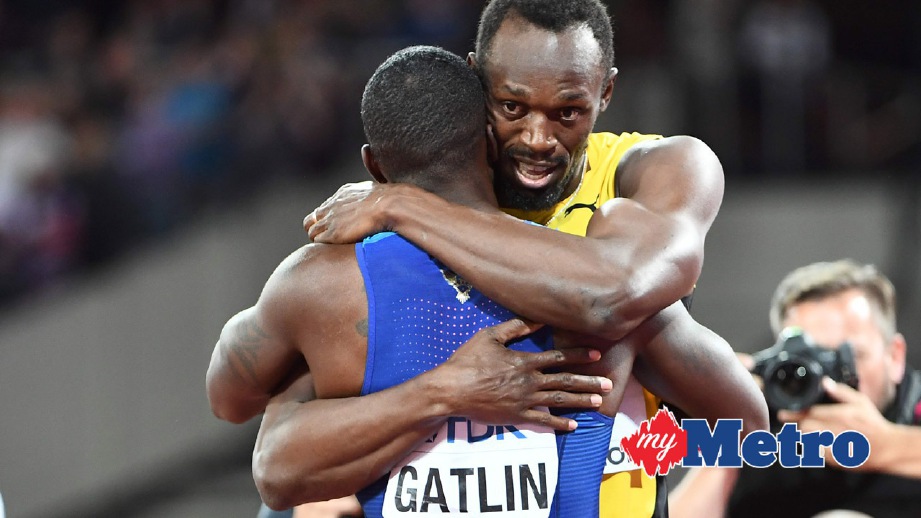 BOLT (kanan) memeluk Gatlin selepas final 100 meter. FOTO AFP