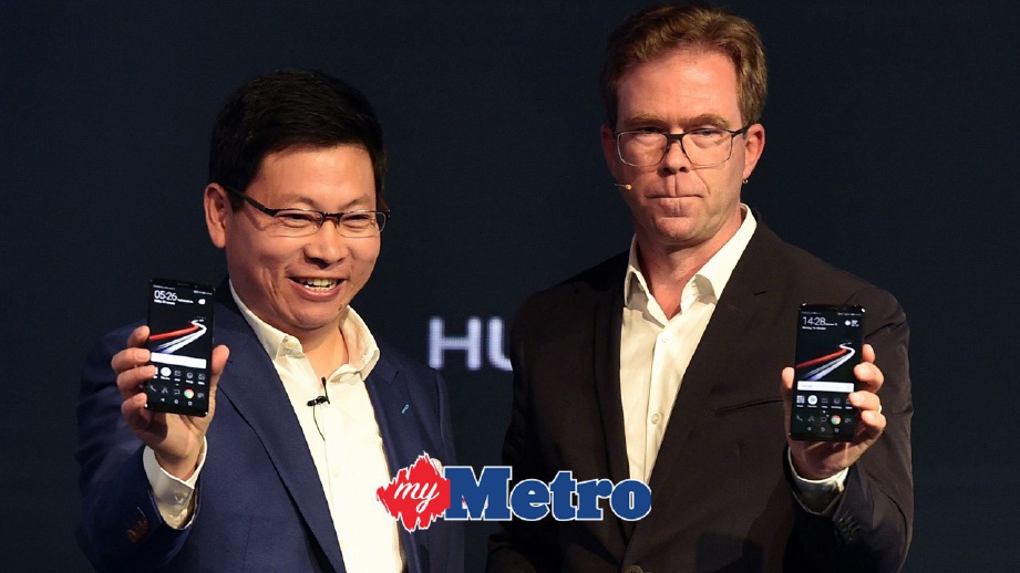 KETUA Pegawai Eksekutif Kumpulan Konsumer Huawei China, Richard Yu (kiri) dan Ketua Pegawai Operasi Porsche Design, Jan Becker (kanan) menunjukkan Huawei Mate 10 yang baru. FOTO AFP