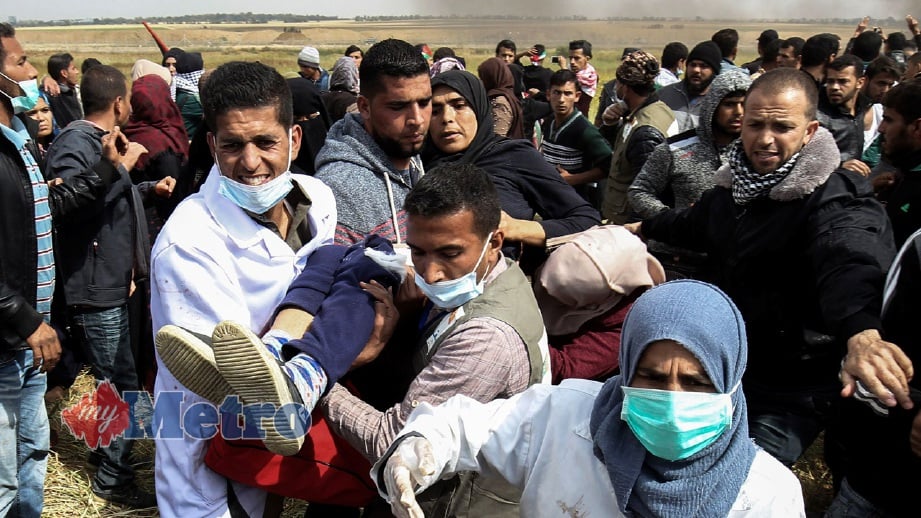 WANITA Palestin cedera diangkat ke tempat selamat. FOTO AFP