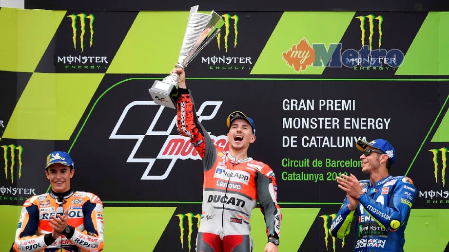 LORENZO (tengah) meraikan kemenangannya diiringi Marquez (kiri) dan Rossi (kanan). FOTO AFP