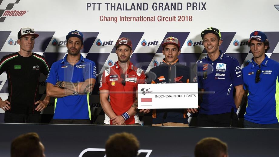 (DARI kiri) PELUMBA Aprilla, Aleix Espargaro; Suzuki, Andrea Iannone; Dovizioso, Marquez; dan Rossi bersama pelumba Suzuki, Alex Rins bergambar bersama papan tada memperingati mangsa tsunami dan tempa bumi di Indonesia. FOTO AFP