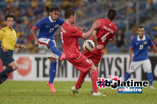 PEMAIN Malaysia Amri Yahyah (dua kiri) cuba menendang bola melepasi pemain Palestin Ahmed Mahajna (dua kanan) dan Tamer Seyam (tengah). FOTO AFP