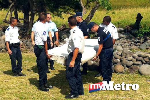 PIHAK berkuasa mengangkut serpihan pesawat yang belum dikenal pasti di Pulau Reunion dekat Madagascar. FOTO AFP