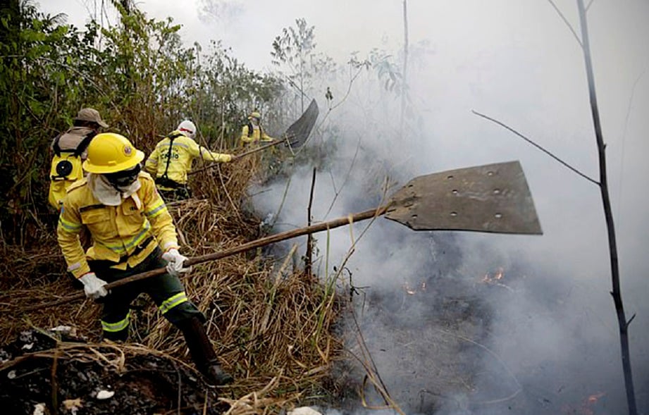 ANGGOTA bomba bertungkus-lumus memadam api kebakaran di Hutan Simpan Jacunda, Brazil semalam. FOTO Mail Online