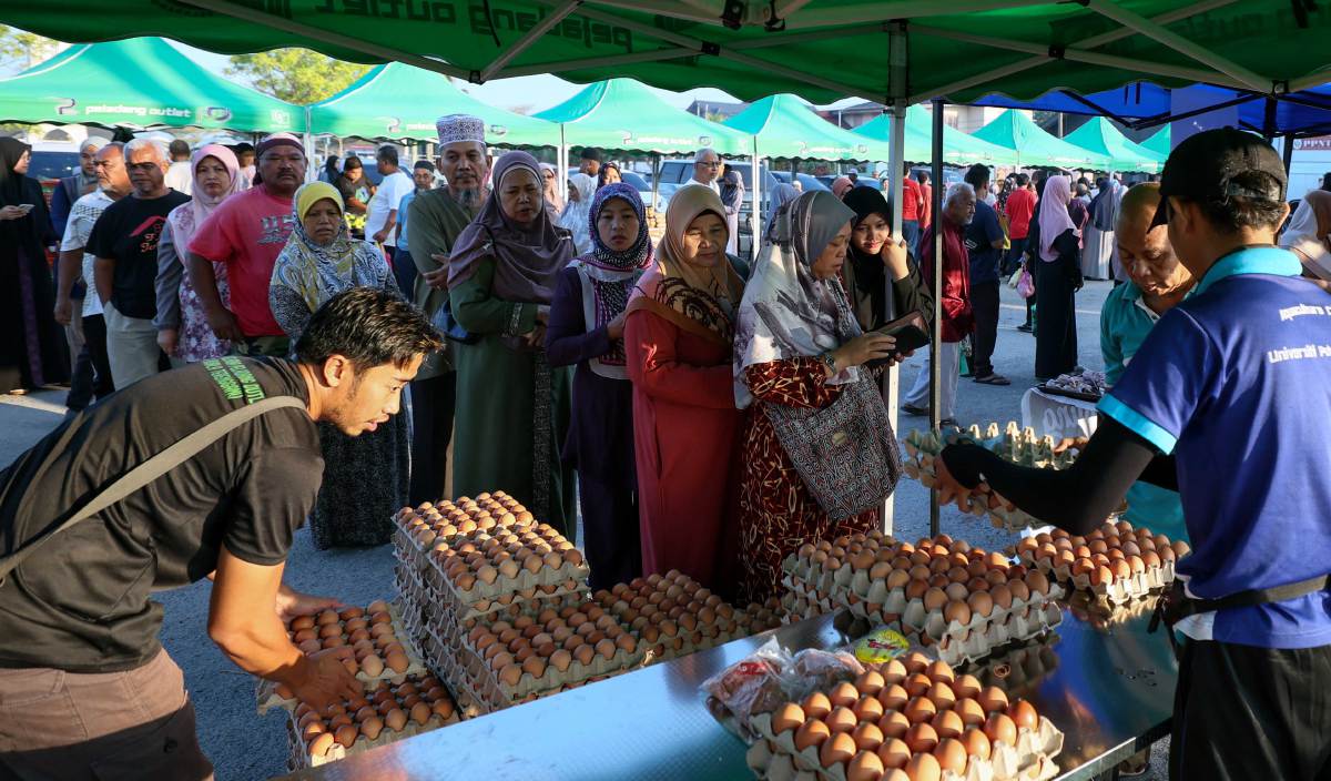 PENDUDUK mendapatkan telur ayam gred B pada harga RM11.80 menerusi Program Jualan Agro MADANI@Peladang Outlet Aidilfitri di Masjid Jamek Pengadang Baru, Kuala Terengganu. FOTO BERNAMA