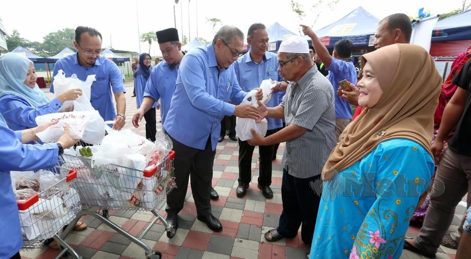 ZAINAL Abidin (tengah) mengagihkan saguhati kepada pelanggan di Majlis Perasmian Agrobazaar Chendering, Kuala Terengganu, hari ini. FOTO Imran Makhzan.