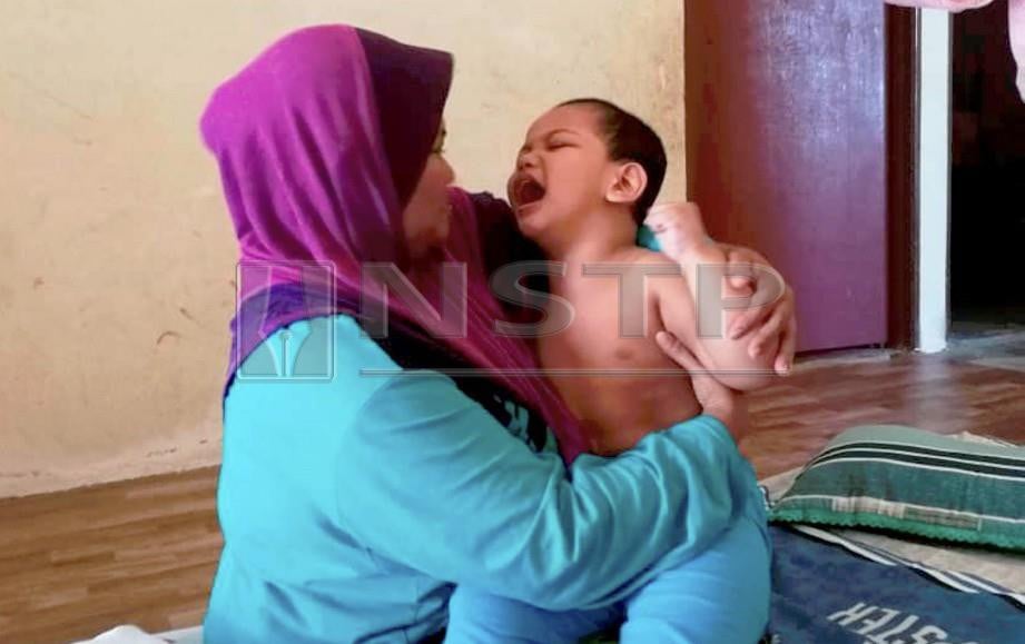 MASZELINA Osman, 39, memangku anak tunggalnya, Ahmad Ammar Ibrahim, 4, yang menghidap cerebral palsy sejak berusia sembilan bulan di rumah sewanya di Kampung Danglau, Sik. FOTO Muhammad Mustakim Ramli