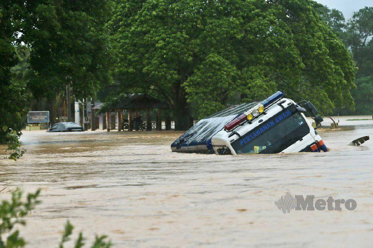 LORI APM terbalik selepas dibawa arus banjir di Kampung Padang Ipoh, Kuala Berang. FOTO Ghazali Kori