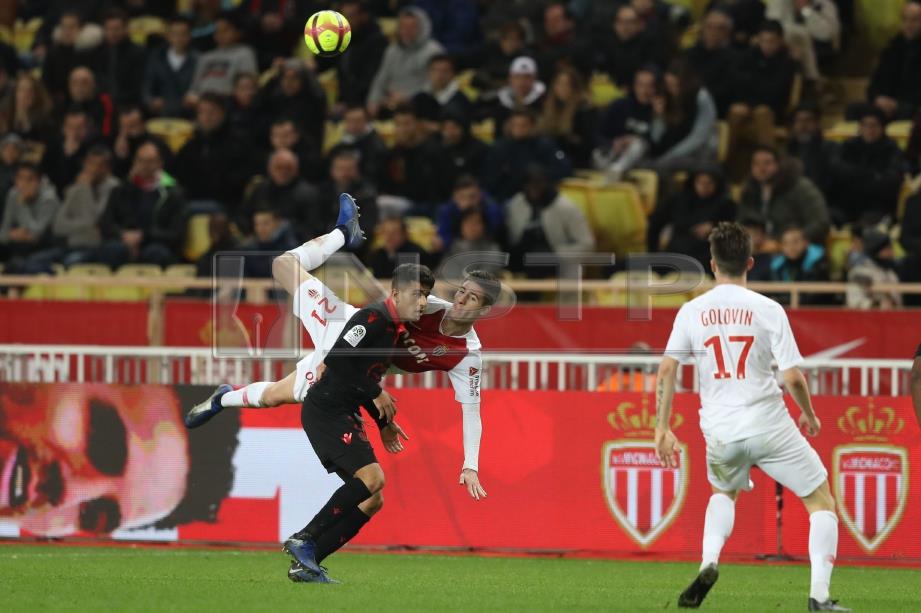 PEMAIN pertahanan Monaco, Julien Serrano (tengah) merampas bola daripada pemain Nice Youcef Atal. FOTO/AFP