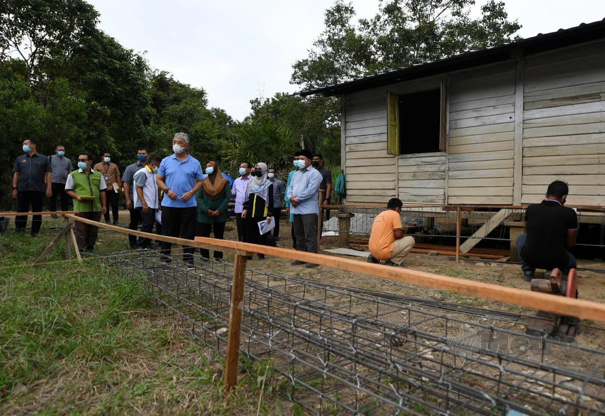 Yang di-Pertuan Agong berkenan melihat proses pembinaan rumah baharu untuk mangsa banjir. FOTO Bernama 