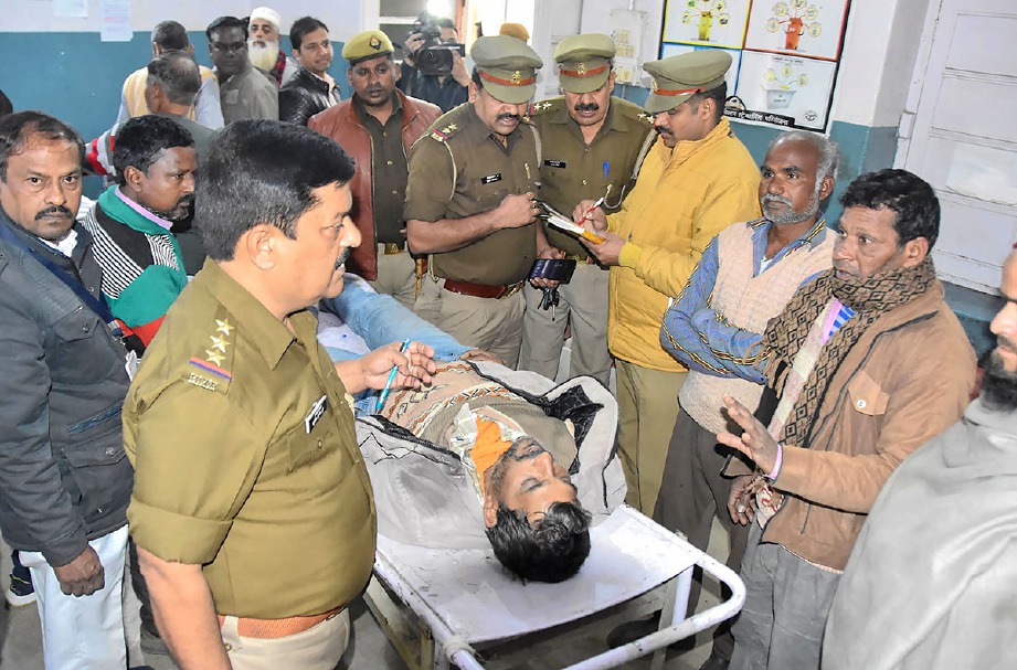 PIHAK polis dan mayat seorang lelaki di Hospital Saharanpur yang maut akibat minum arak haram yang beracun di Uttar Pradesh. FOTO AFP
