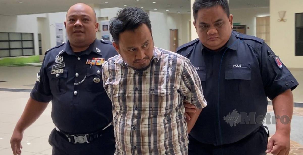 Asran Mohd Tahir dibawa keluar dari Mahkamah Sesyen Muar selepas gagal membayar ikat jamin RM10,000. FOTO Alias Abd Rani