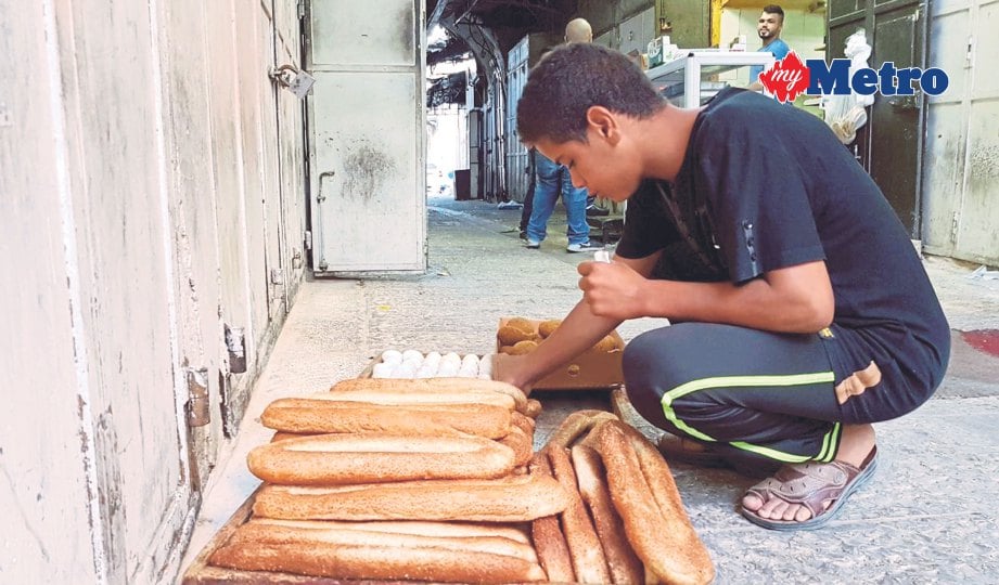 REMAJA Palestin menyediakan roti untuk dijual di sekitar kompleks Masjid Al-Aqsa. FOTO Amir Abd Hamid 