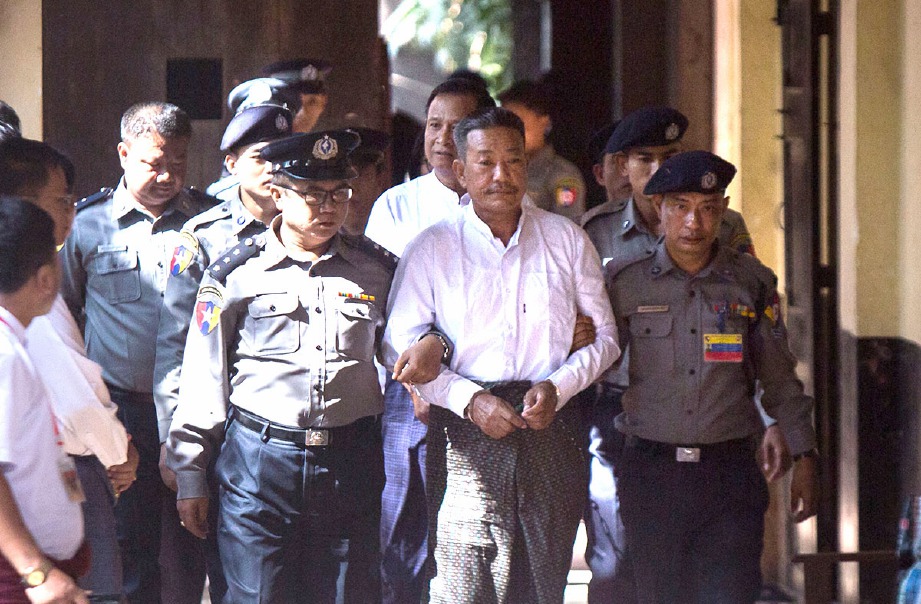 KYI LIN (dua dari kanan) diekori Aung Win Zaw diiringi polis ke mahkamah. FOTO AFP