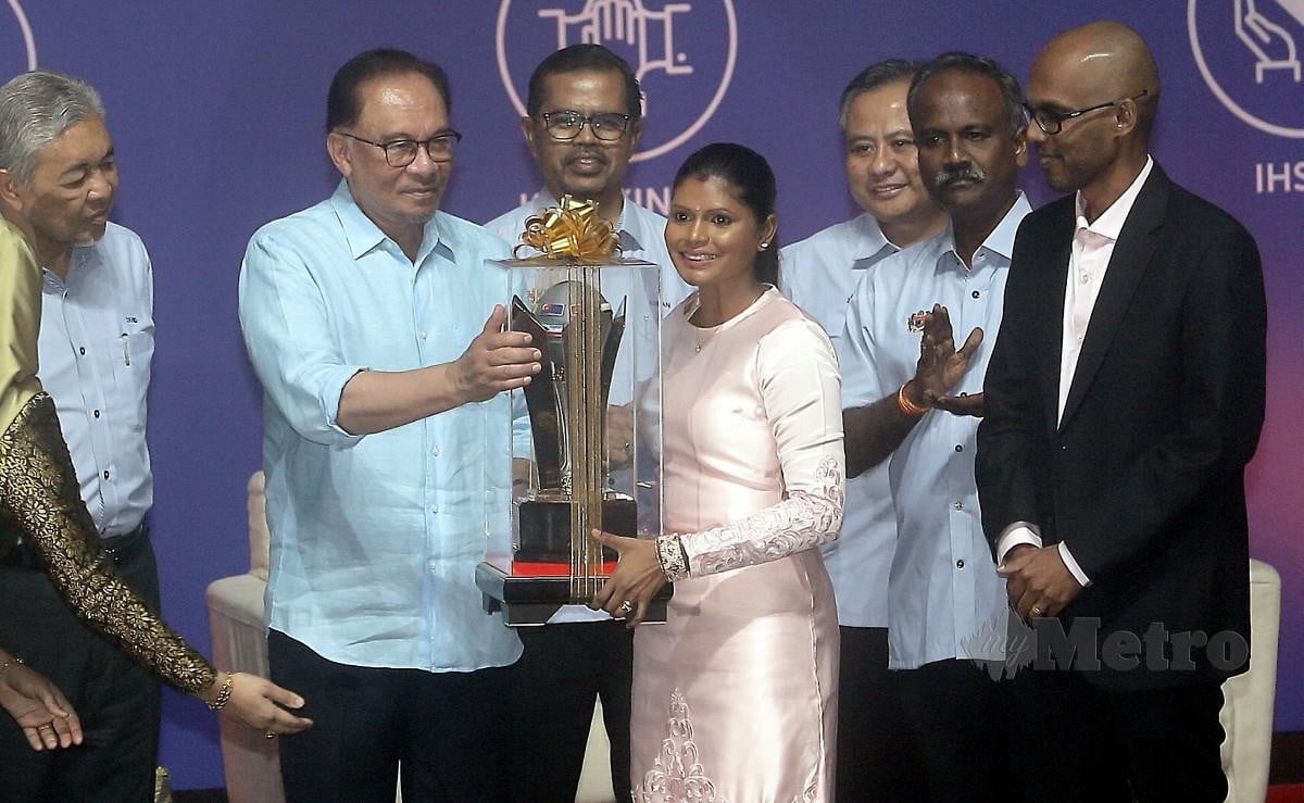 ANWAR menyampaikan Anugerah Pekerja Contoh kepada Dr Malar ketika Sambutan Hari Pekerja 2023 di Putrajaya. FOTO Mohd Fadli Hamzah.