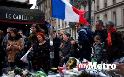 ORANG ramai berkumpul di depan kafe Le Carillon iaitu lokasi serangan di Paris, Jumaat lalu. FOTO AP