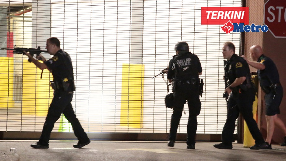 ANGGOTA polis bertindak selepas tembakan dilepaskan ketika tunjuk perasaan di Dallas. FOTO AP