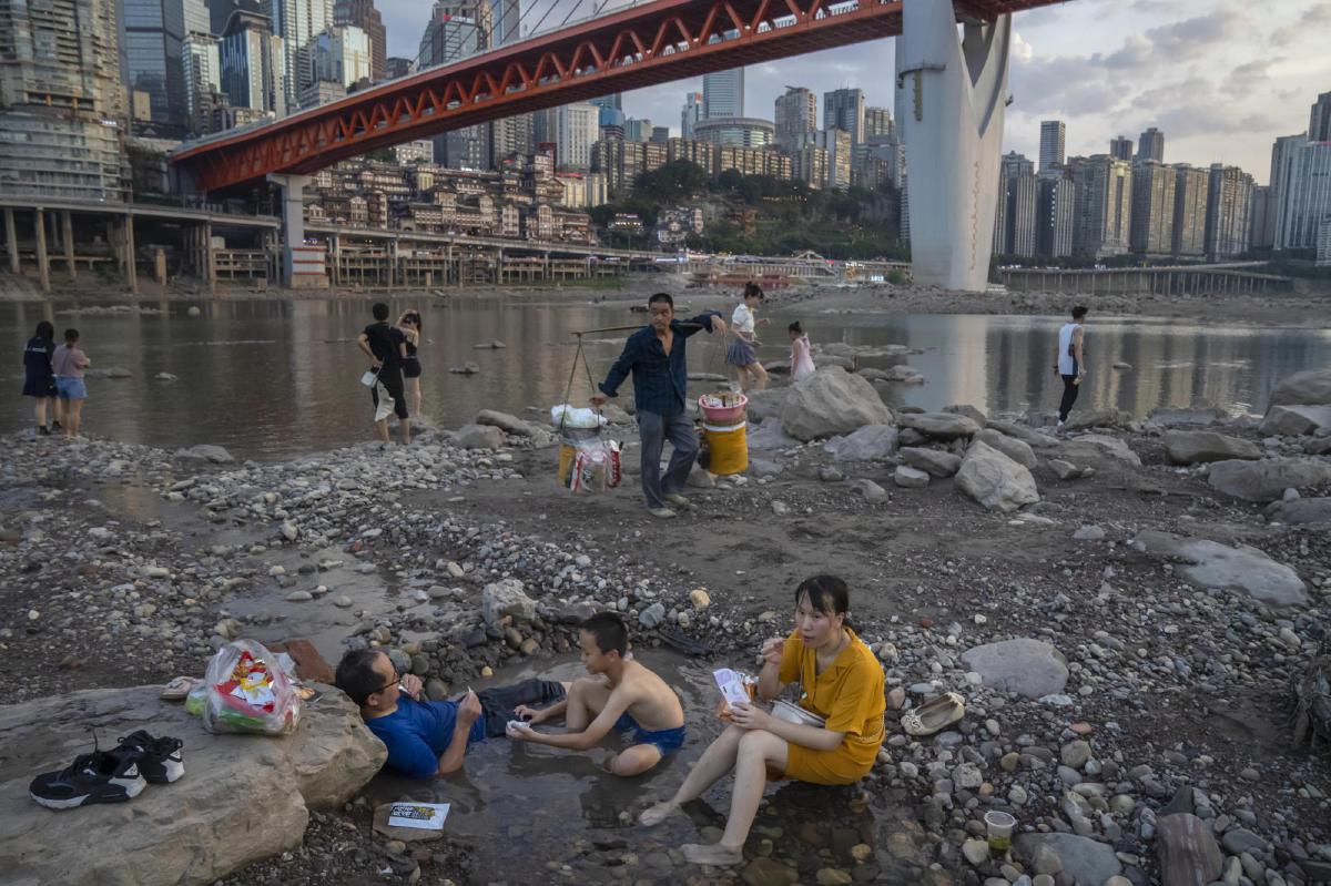 ORANG ramai bersantai di Sungai Jialing di Chongqing, bandar barat daya China, yang menjadi cetek kerana kemarau. FOTO AP
