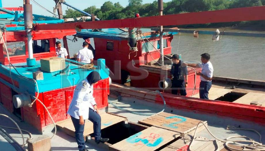 Anggota penguat kuasa APMM Zon Maritim Kuala Kedah memeriksa bot yang disyaki menangkap siput secara haram berhampiran pantai Kuala Sala. FOTO Ihsan APMM 