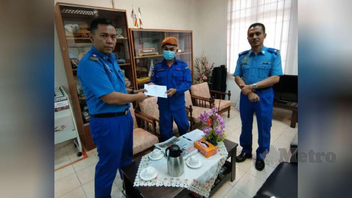 SHAHRUL Riedzuan (tengah) menerima wang tunai RM200 daripada Effendy sambil diperhatikan Timbalannya, Mejar Kamarulsyah Muslim di Pejabat APM negeri di Ayer Keroh, hari ini. FOTO ihsan APM