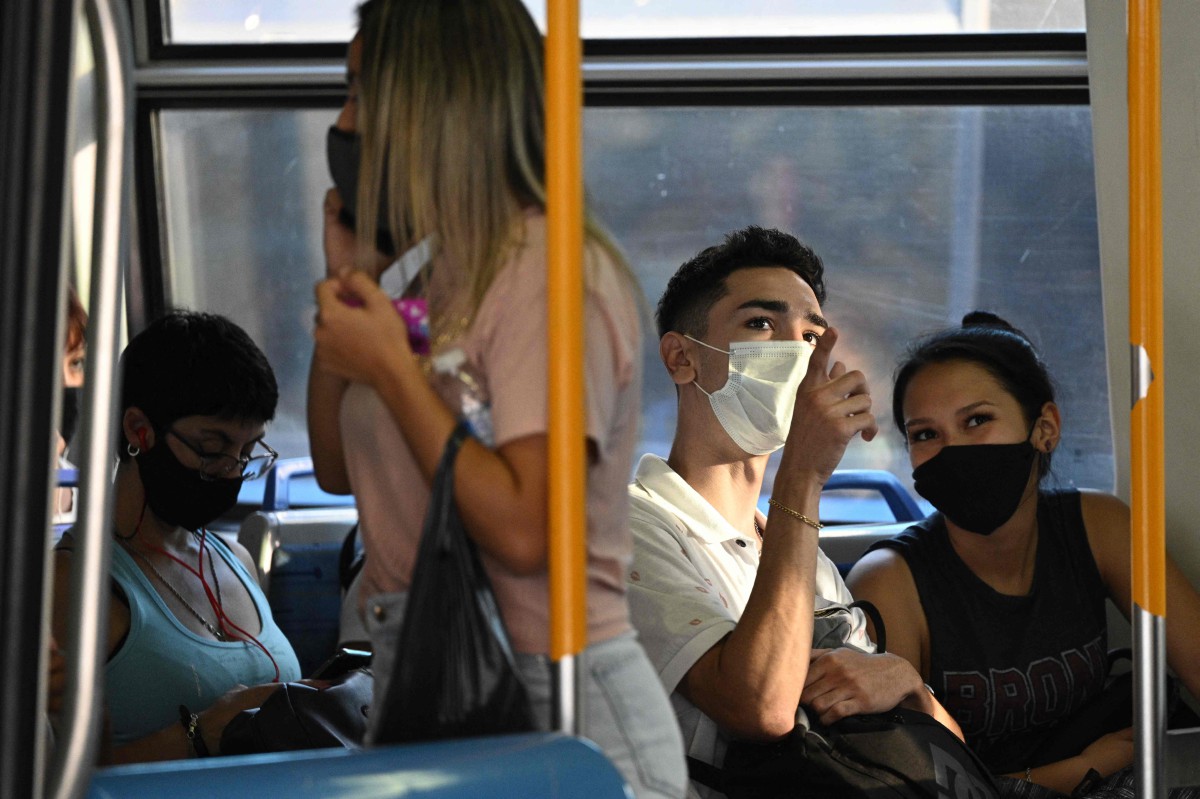 ORANG ramai memakai pelitup muka ketika menaiki pengangkutan awam di Buenos Aires. FOTO AFP 