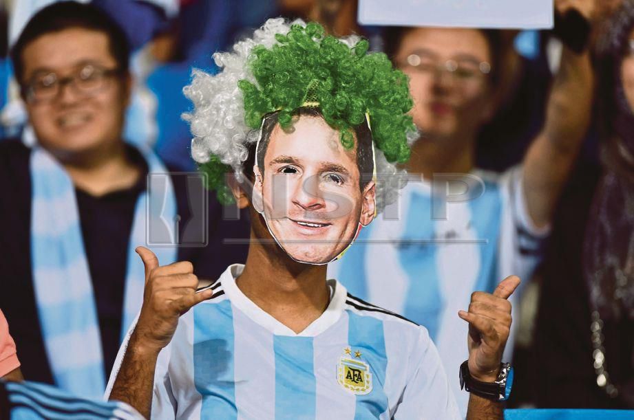 PENYOKONG Argentina memakai topeng bermuka Messi. FOTO/REUTERS  