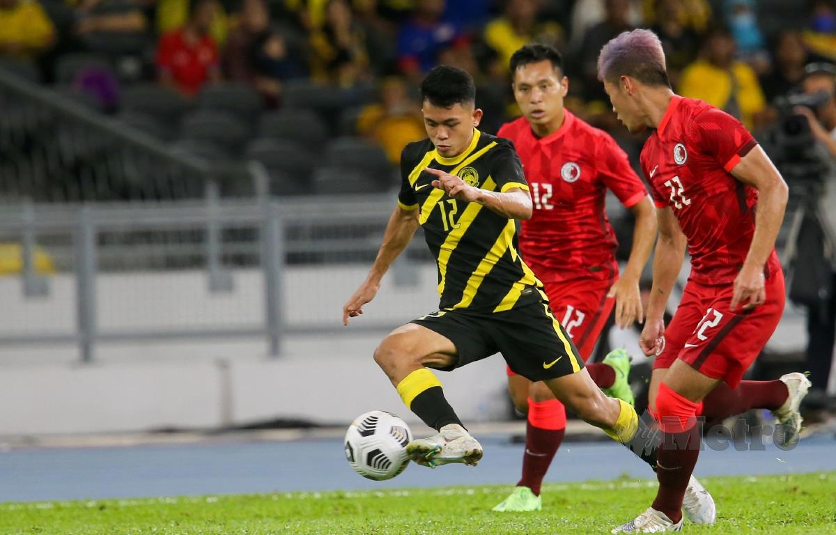 PEMAIN sayap Harimau Malaya, Arif Aiman Hanapi (kiri) cuba menggelecek pemain Hong Kong pada perlawanan di Stadium Nasional Bukit Jalil, malam tadi. FOTO ASWADI ALIAS.