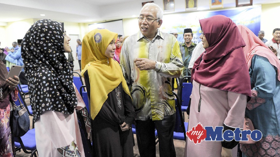 MAHDZIR beramah mesra dengan penuntut selepas menyampaikan sumbangan. FOTO Muhd Adib