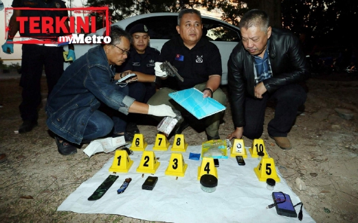 ABD Jalil (dua kanan) bersama Ketua Jabatan Siasatan Jenayah Kedah, Senior Assisten Komisioner Mohd Nashir Ya (kiri) menunjukkan senjata serta barang yang ditemui di kereta suspek. FOTO Amran Hamid